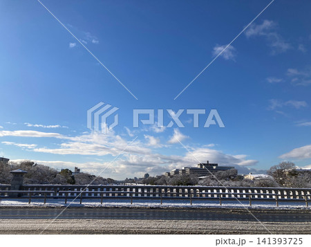 雪の積もった橋の欄干と冬の街並みの景色 雪の積もった橋の欄干と冬の街並みの景色 141393725