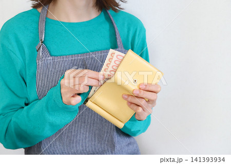 財布からお金を取り出す女性　家計管理イメージ 141393934