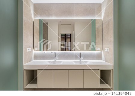 Modern bathroom interior with double sinks, illuminated mirror, sleek cabinetry, neutral tones, and spacious minimalist design for refined home renovation, with bathroom, modern, interior, double Modern bathroom interior with double sinks, illuminated mirror, sleek cabinetry, neutral tones, and spacious minimalist design for refined home renovation, with bathroom, modern, interior, double 141394045