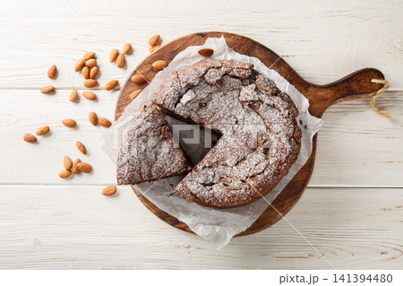 Torta caprese is a flourless chocolate cake made with almonds closeup on the wooden board. Horizontal top view Torta caprese is a flourless chocolate cake made with almonds closeup on the wooden board. Horizontal top view 141394480