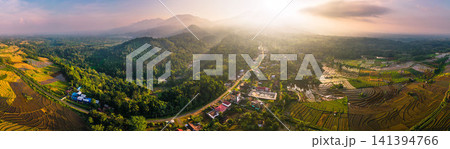 Aerial view of the lush Tegalalang landscape featuring a winding river flowing through dense tropical forest and terraced fields in Indonesia Aerial view of the lush Tegalalang landscape featuring a winding river flowing through dense tropical forest and terraced fields in Indonesia 141394766