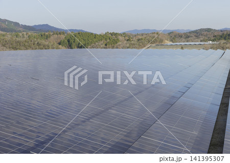 山々を背景に広がる太陽光発電パネルの俯瞰 山々を背景に広がる太陽光発電パネルの俯瞰 141395307