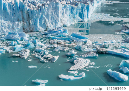 Perito Moreno glacier landscape with climate change showing melting blue ice fragment floating in cold water creates feeling of sadness for nature and concern about global environment in Patagonia Perito Moreno glacier landscape with climate change showing melting blue ice fragment floating in cold water creates feeling of sadness for nature and concern about global environment in Patagonia 141395469