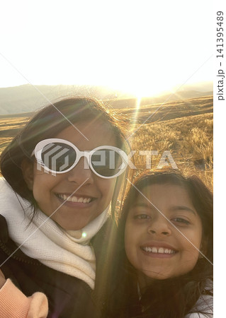 Family posing in golden field at sunset. UGC 141395489