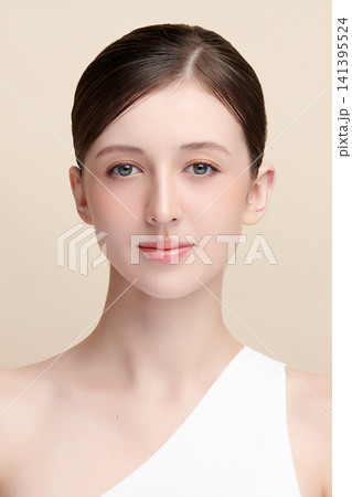 A beautiful young Asian woman with clean, fresh skin against a beige background. Skincare, facial treatment, cosmetology, beauty, and spa. An elegant portrait of an Asian woman. A beautiful young Asian woman with clean, fresh skin against a beige background. Skincare, facial treatment, cosmetology, beauty, and spa. An elegant portrait of an Asian woman. 141395524