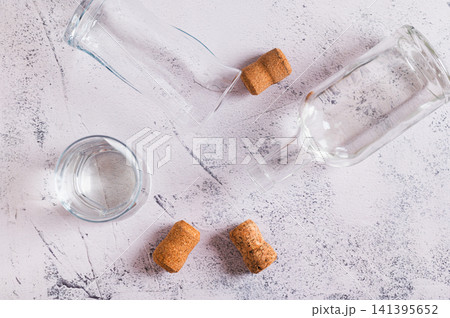 Concept of alcoholism - empty glasses, corks and a bottle on the table top view Concept of alcoholism - empty glasses, corks and a bottle on the table top view 141395652