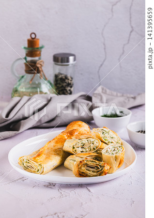 Delicious grilled rolls with cottage cheese, cheese and herbs on a plate on the table vertical view Delicious grilled rolls with cottage cheese, cheese and herbs on a plate on the table vertical view 141395659