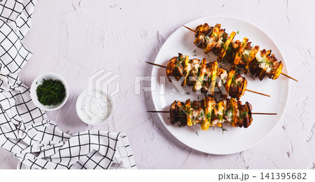 Sulvaki made from meat and potatoes on skewers on a plate on the table top view web banner Sulvaki made from meat and potatoes on skewers on a plate on the table top view web banner 141395682