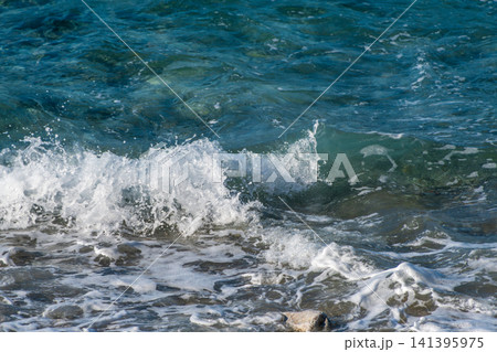 澄み渡る青い海と白く打ち寄せる波の表情 141395975