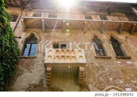 Juliet Balcony in Verona with Bright Sunlight Flare on Old Brick house Facade. Juliet Balcony in Verona with Bright Sunlight Flare on Old Brick house Facade. 141396042