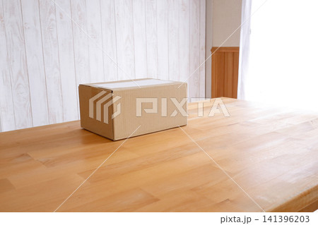 ナチュラルインテリアの部屋に置かれたダンボール箱の荷物 141396203