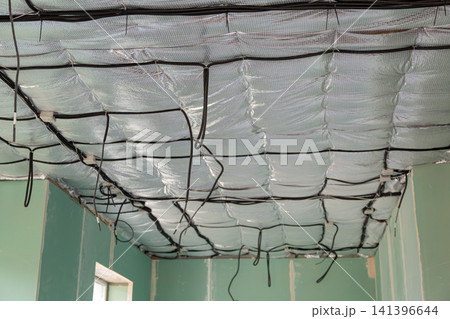 Electrical cable installation above insulated ceiling during house construction Electrical cable installation above insulated ceiling during house construction 141396644