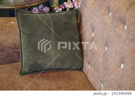top view closeup green pillow layered placed on a brown leather sofa, object, decor, fashion, copy space 141396999