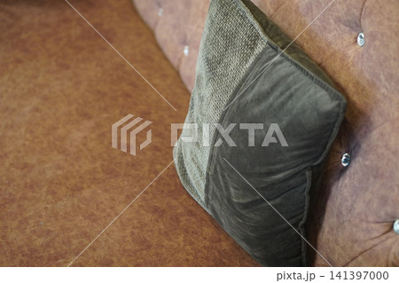 top view closeup green pillow layered placed on a brown leather sofa, object, decor, fashion, old, antique, copy space 141397000