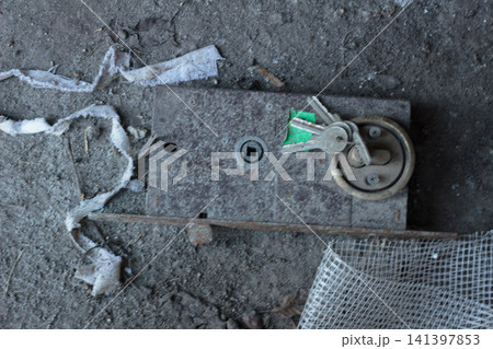Old rusty door lock mechanism with keys on a dusty floor Old rusty door lock mechanism with keys on a dusty floor 141397853
