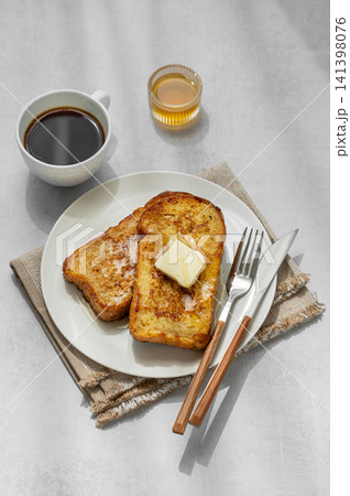 Brioche toasts with butter and honey on a plate on a concrete background Brioche toasts with butter and honey on a plate on a concrete background 141398076