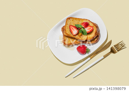 Brioche toasts with strawberries and honey on a plate on a yellow background Brioche toasts with strawberries and honey on a plate on a yellow background 141398079