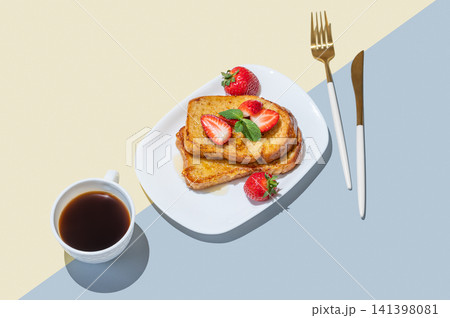 Brioche toasts with strawberries and honey on a plate on a yellow blue background Brioche toasts with strawberries and honey on a plate on a yellow blue background 141398081