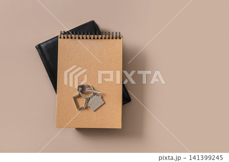 House keys on notebook and planner on beige background 141399245