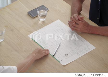 離婚届を見ながら話し合うシニア夫婦 離婚届を見ながら話し合うシニア夫婦 141399549