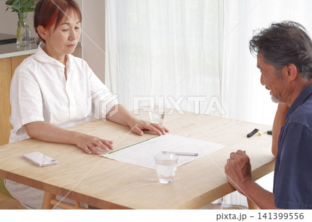 離婚届を見ながら話し合うシニア夫婦 離婚届を見ながら話し合うシニア夫婦 141399556