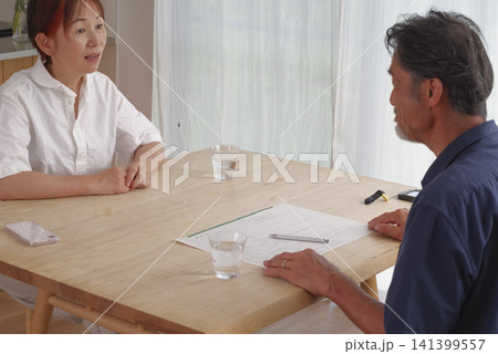 離婚届を見ながら話し合うシニア夫婦 離婚届を見ながら話し合うシニア夫婦 141399557