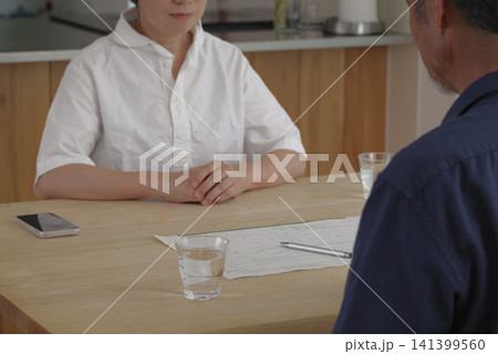 離婚届を見ながら話し合うシニア夫婦 離婚届を見ながら話し合うシニア夫婦 141399560
