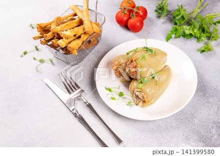 Stuffed bell peppers with meat and rice, served with crispy fries Stuffed bell peppers with meat and rice, served with crispy fries 141399580
