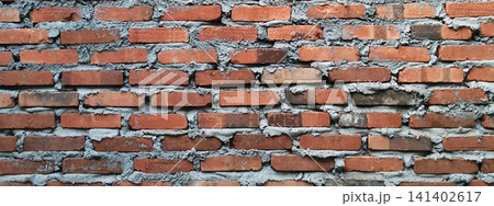Panoramic texture of a raw red brick wall with cement mortar. Panoramic texture of a raw red brick wall with cement mortar. 141402617