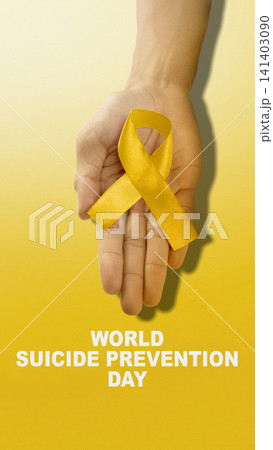 An open hand holding a yellow awareness ribbon for World Suicide Prevention Day on a yellow gradient background, representing mental health support and hope An open hand holding a yellow awareness ribbon for World Suicide Prevention Day on a yellow gradient background, representing mental health support and hope 141403090