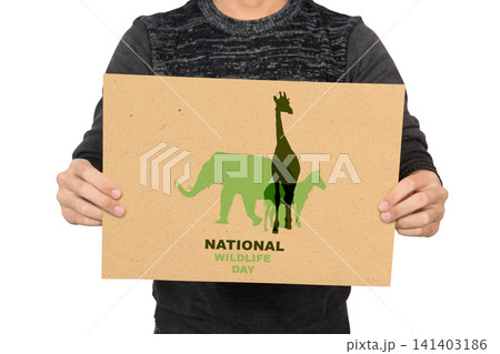 A close-up of a person holding a cardboard sign featuring animal silhouettes to celebrate National Wildlife Day A close-up of a person holding a cardboard sign featuring animal silhouettes to celebrate National Wildlife Day 141403186