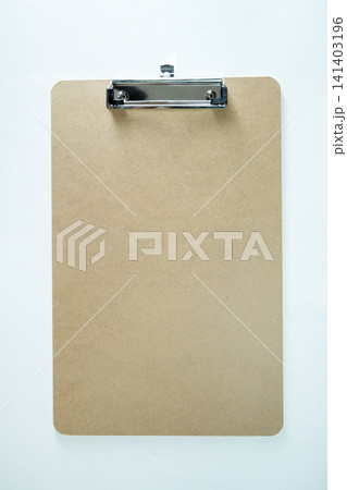 Empty brown fiberboard clipboard with a metal clip on a clean, textured white background, ideal for mockups and checklists Empty brown fiberboard clipboard with a metal clip on a clean, textured white background, ideal for mockups and checklists 141403196