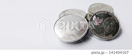Close-up photo of a stack of Indonesian Rupiah coins against a white background with empty space. Close-up photo of a stack of Indonesian Rupiah coins against a white background with empty space. 141404107