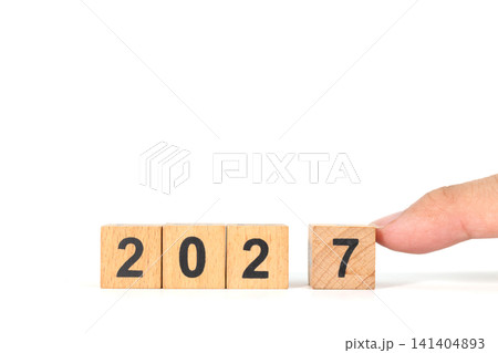 Hand Placing Wooden Number Block 2027 New Year Concept on White Background Hand Placing Wooden Number Block 2027 New Year Concept on White Background 141404893