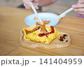 woman eating pizza with spoon, fork and knife 141404959