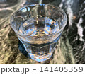 大理石模様のテーブル上の水が入ったグラス 141405359