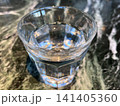 大理石模様のテーブル上の水が入ったグラス 141405360