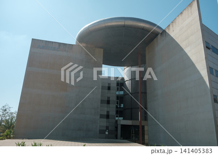 minimalist architecture: Modern building with sleek concrete walls and striking circular metallic overhang. Industrial design with clean lines and bold presence, perfect for urban lifestyle concepts. minimalist architecture: Modern building with sleek concrete walls and striking circular metallic overhang. Industrial design with clean lines and bold presence, perfect for urban lifestyle concepts. 141405383
