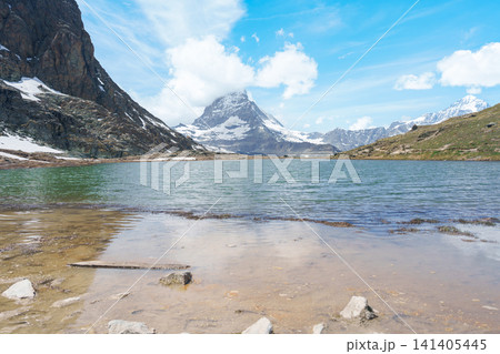 Iconic Reflection of Matterhorn Mountain in Riffelsee Lake, Zermatt, Switzerland, Snow Capped Swiss Alps under Blue Sky, Famous Landmark landscape and popular European Travel Destination Iconic Reflection of Matterhorn Mountain in Riffelsee Lake, Zermatt, Switzerland, Snow Capped Swiss Alps under Blue Sky, Famous Landmark landscape and popular European Travel Destination 141405445