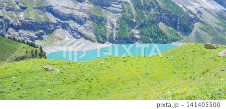 Scenic landscape of Oeschinensee or turquoise Oeschinen Lake in summer under blue sky with wildflowers and Stunning Swiss Alps. Spectacular green meadow hiking trail view, Kandersteg, Switzerland Scenic landscape of Oeschinensee or turquoise Oeschinen Lake in summer under blue sky with wildflowers and Stunning Swiss Alps. Spectacular green meadow hiking trail view, Kandersteg, Switzerland 141405500