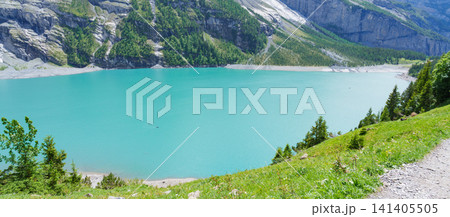 High angle view of turquoise Oeschinensee or Oeschinen Lake in summer with rowing boats. Stunning aerial view of tourists kayaking from hiking trail, beautiful Swiss Alps, Kandersteg, Switzerland High angle view of turquoise Oeschinensee or Oeschinen Lake in summer with rowing boats. Stunning aerial view of tourists kayaking from hiking trail, beautiful Swiss Alps, Kandersteg, Switzerland 141405505