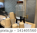 台の上の冷水ディスペンサーと紙コップ 141405560