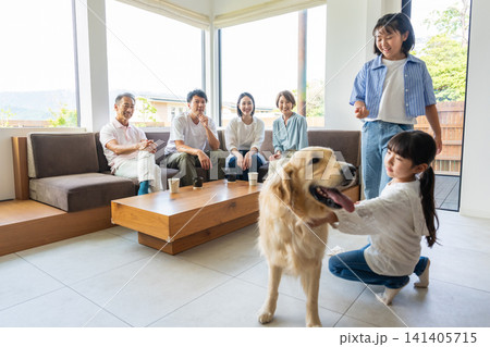 リビングで愛犬と触れ合う3世代の家族 リビングで愛犬と触れ合う3世代の家族 141405715