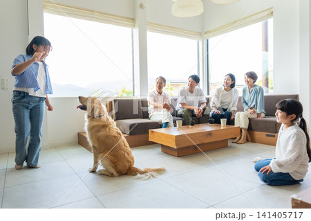 リビングで愛犬と触れ合う3世代の家族 リビングで愛犬と触れ合う3世代の家族 141405717