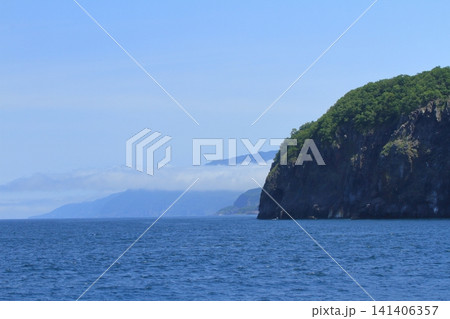 低い帯状の雲が浮かぶ知床半島の海上の風景 低い帯状の雲が浮かぶ知床半島の海上の風景 141406357