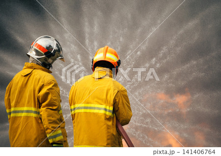 Firefighters extinguishing a burning car with a water hose Firefighters extinguishing a burning car with a water hose 141406764