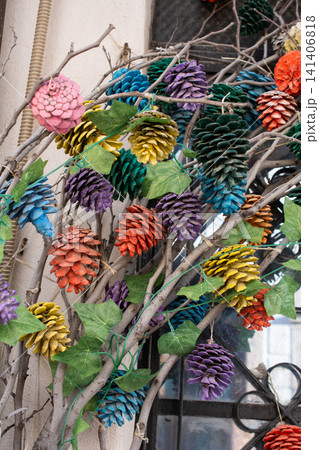 Vibrant Painted Pinecones and Green Leaves in Artistic Arrangement Vibrant Painted Pinecones and Green Leaves in Artistic Arrangement 141406818