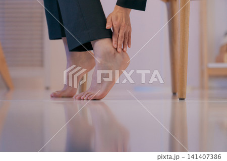足を抑えるスーツの女性のパーツカット 141407386