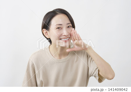 口元に手を添えて呼びかける女性 白背景 口元に手を添えて呼びかける女性 白背景 141409042
