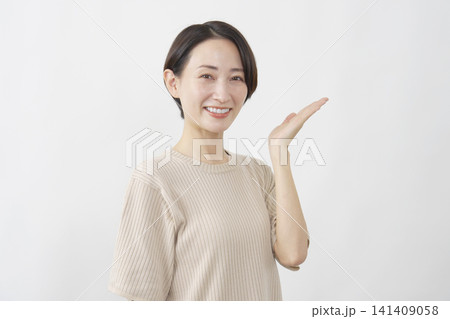 手のひらで指し示す笑顔の女性 白背景 手のひらで指し示す笑顔の女性 白背景 141409058